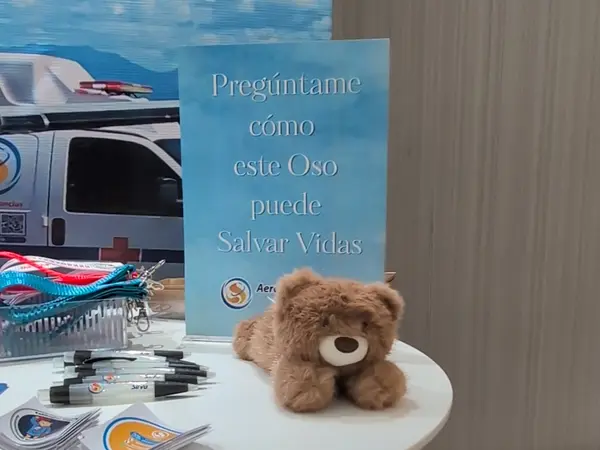 Héroe de Rescate sobre la mesa del stand, junto al cartel de la campaña